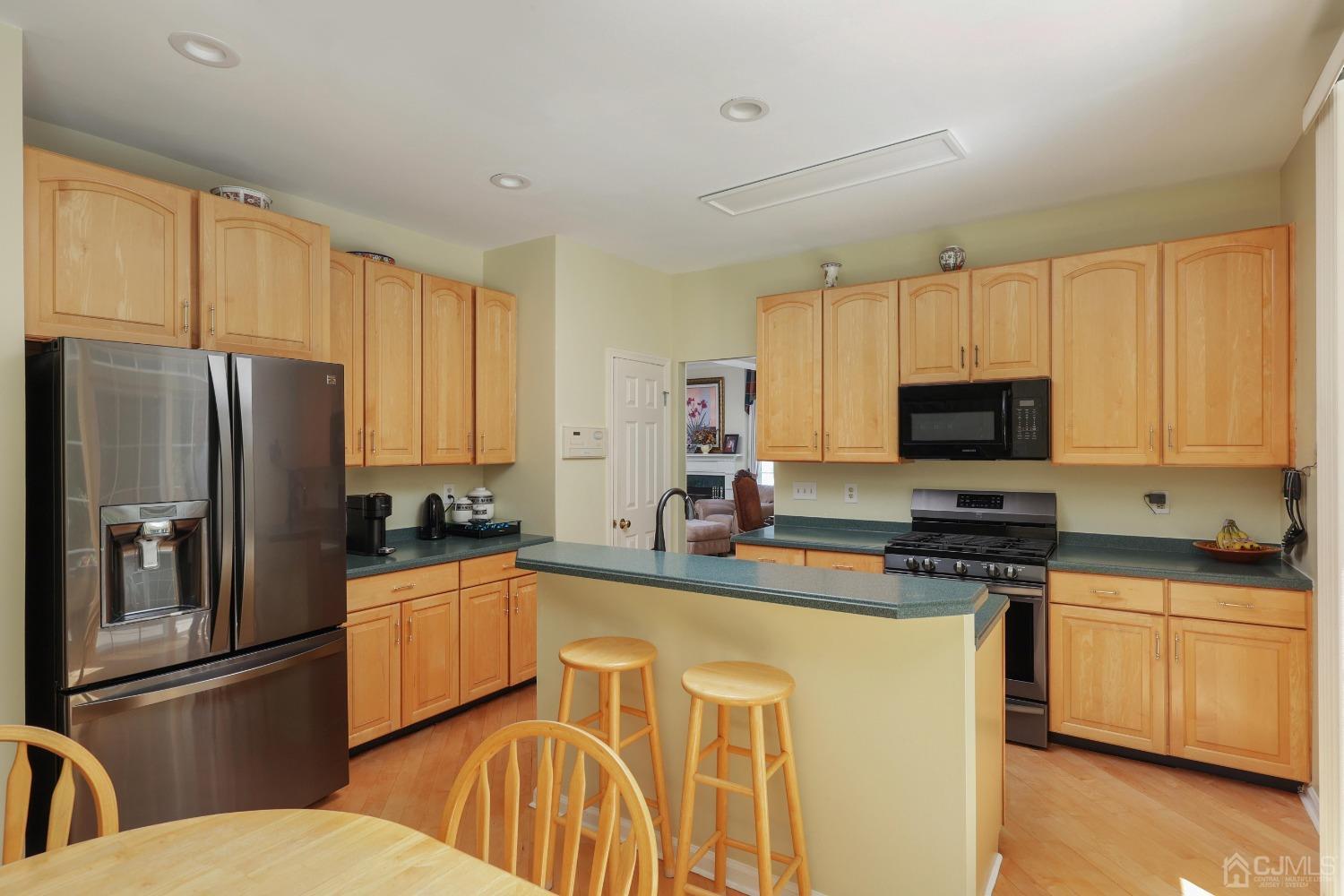 7 Yardley Manor Drive Old Bridge, NJ 07747 - Photo 9 of 23 a kitchen with stainless steel appliances granite countertop a refrigerator a stove a sink dishwasher and white cabinets with wooden floor