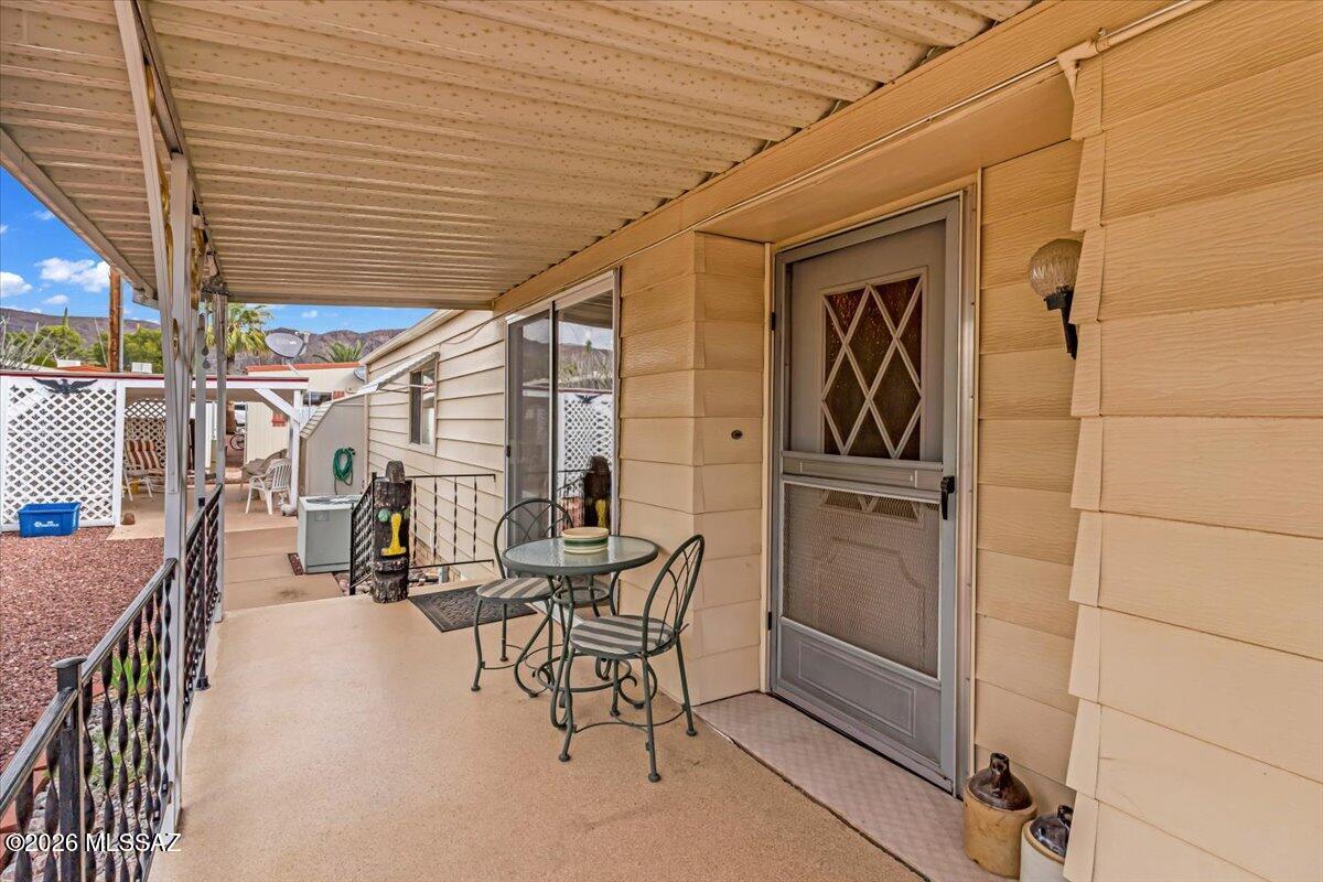 5840 West Flying W Street Tucson, AZ 85713 - Photo 32 of 38 a view of a patio with table and chairs with wooden floor and fence
