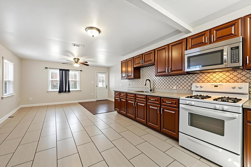 5309 Prock Lane Austin, TX 78721 - Photo 8 of 22 a kitchen with stainless steel appliances granite countertop a stove a sink and a microwave
