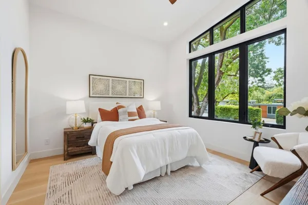 a bedroom with a bed and a large window