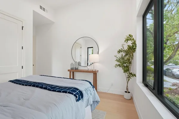 a bedroom with a bed and a large window