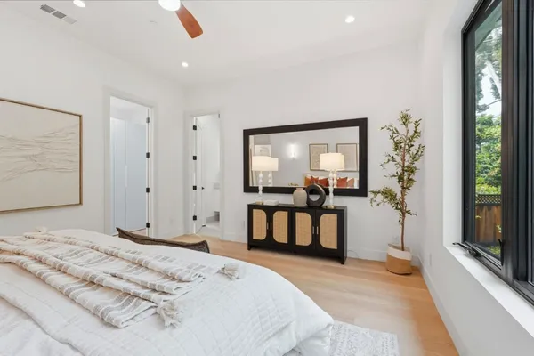a bedroom with a bed and a large mirror