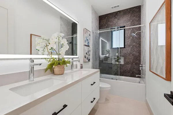 a bathroom with a sink a toilet and shower