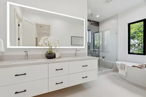 a bathroom with a granite countertop sink mirror and window
