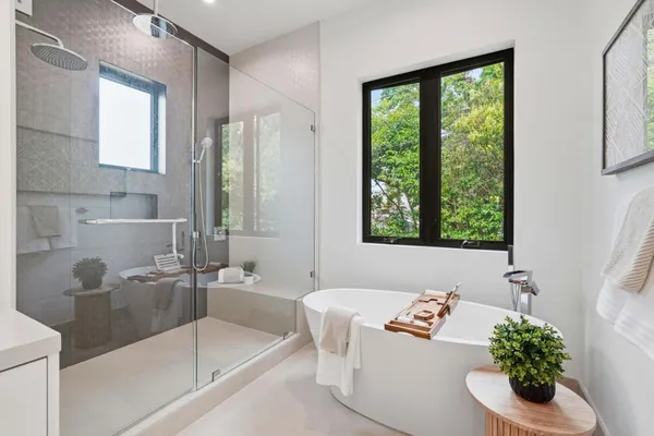 a bathroom with a tub a sink and a window
