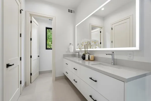 a bathroom with double sink and a mirror