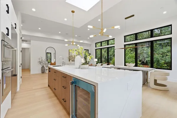 a large white kitchen with a large window