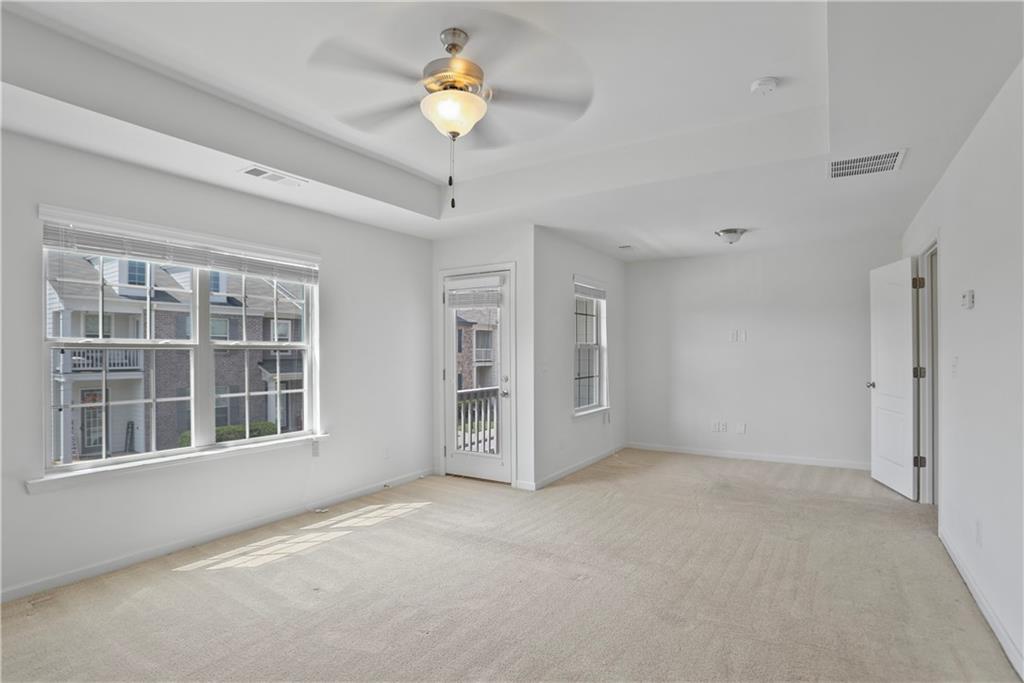 7725 Rutgers Circle Fairburn, GA 30213 - Photo 13 of 20 a view of an empty room with a window and chandelier fan