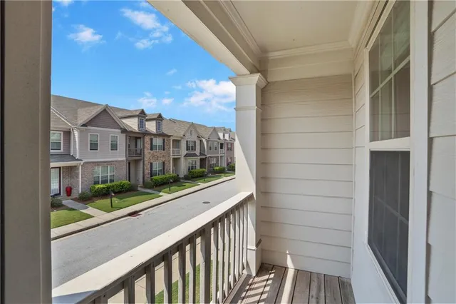 a view of balcony with a yard and wooden fence