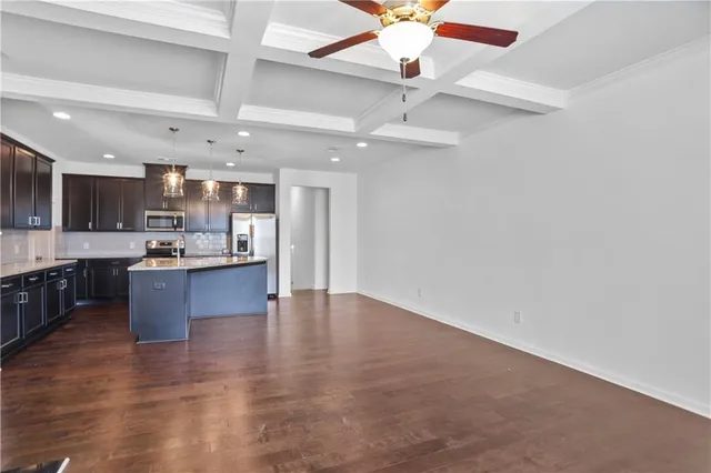 a large kitchen with a center island stainless steel appliances and a chandelier