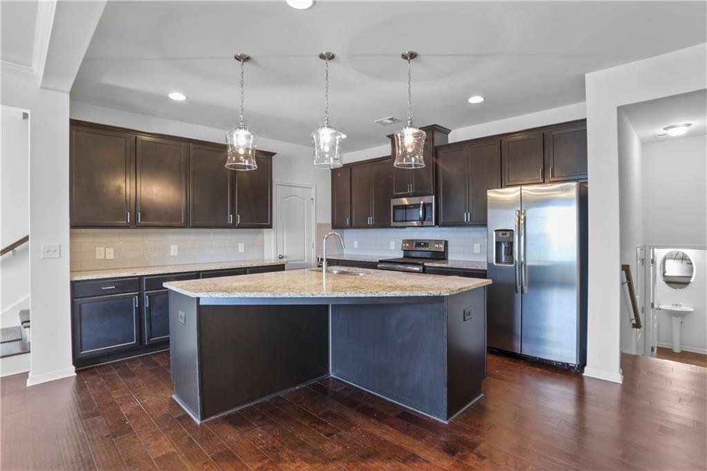 7725 Rutgers Circle Fairburn, GA 30213 - Photo 7 of 20 a kitchen with stainless steel appliances granite countertop a sink a stove and a refrigerator