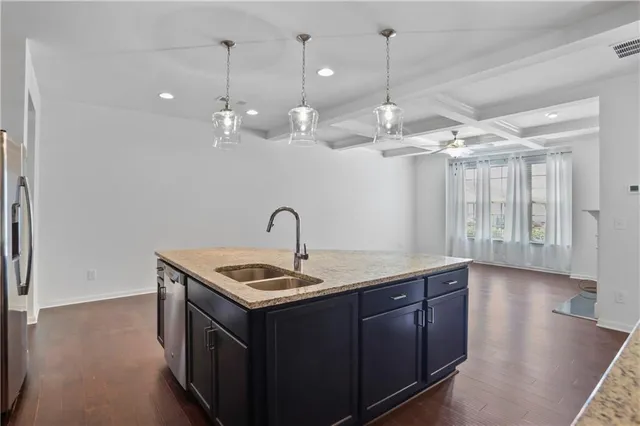 a kitchen that has a sink a refrigerator and chandelier