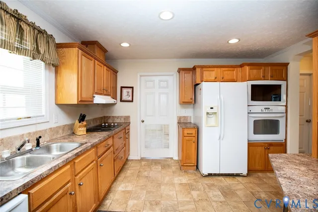 a kitchen with stainless steel appliances granite countertop a refrigerator sink and stove