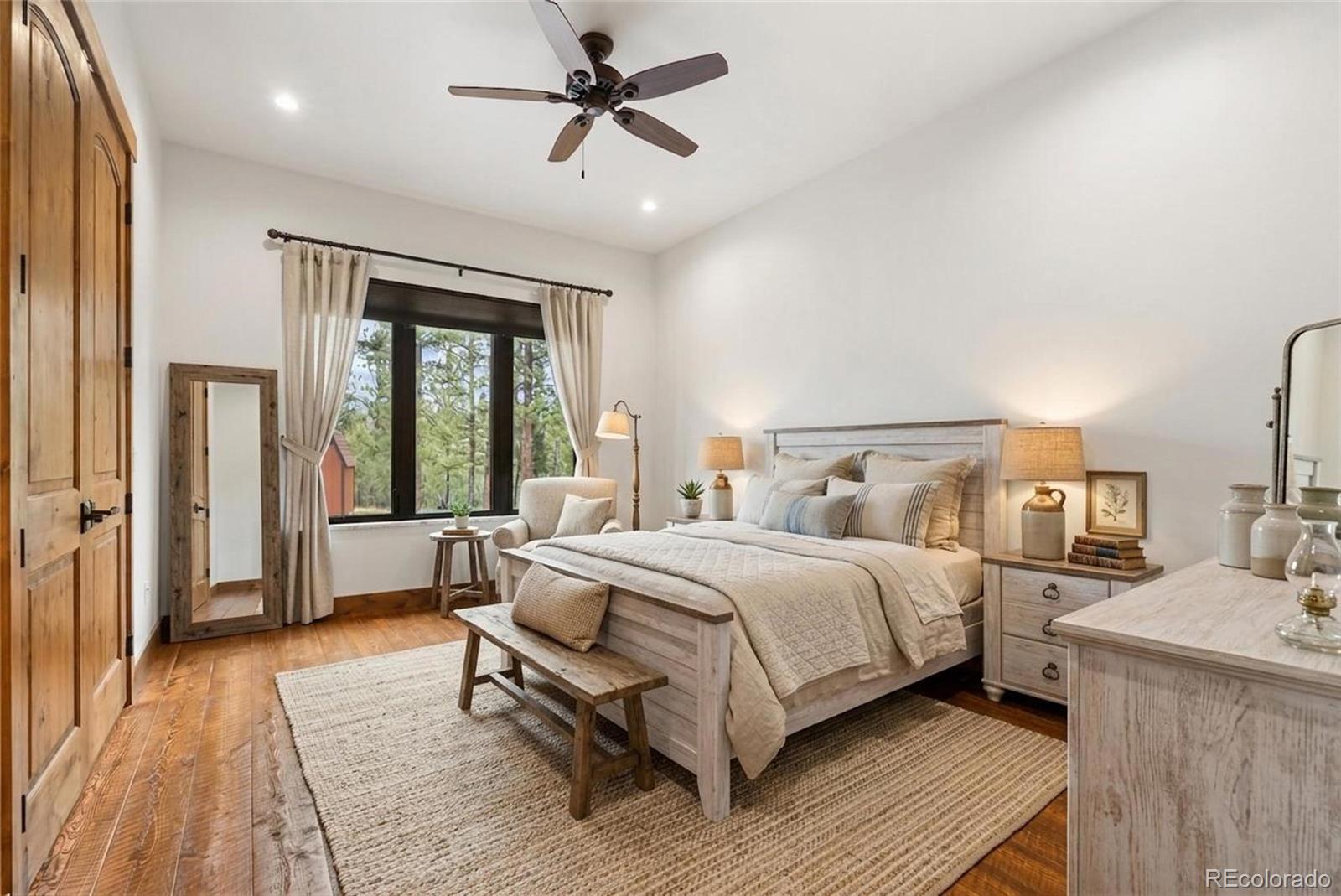 280 Double Tree Road Bailey, CO 80421 - Photo 20 of 43 a bedroom with a large bed and a chandelier