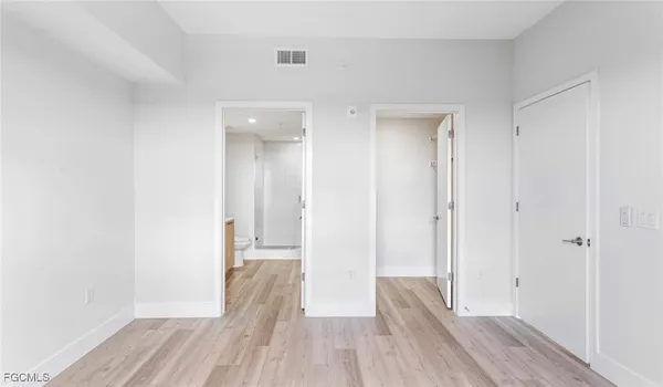 a view of a room with wooden floor and a hallway