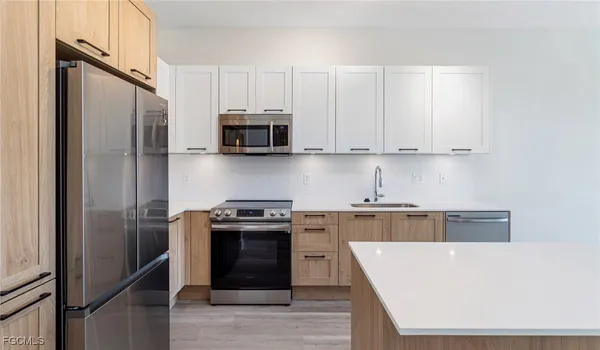 a kitchen with stainless steel appliances granite countertop a stove a refrigerator and a sink