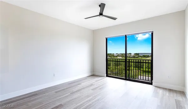 a view of a room with wooden floor fan and window