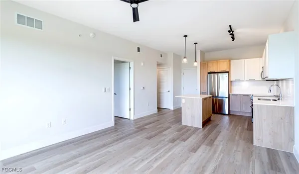 a view of kitchen with stainless steel appliances refrigerator stove microwave and cabinets