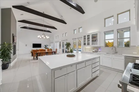 a kitchen with a sink dishwasher and white cabinets with wooden floor