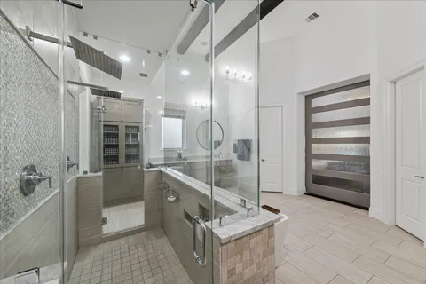 a bathroom with a granite countertop sink a mirror and shower