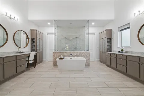 a spacious bathroom with a double vanity sink mirror and bathtub