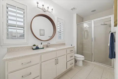 a bathroom with a double vanity sink mirror and toilet