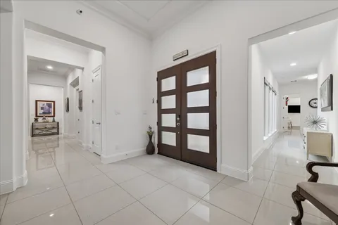 a view of a hallway with wooden floor and seating space