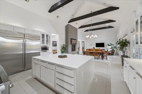 a kitchen with stainless steel appliances kitchen island a refrigerator sink and cabinets