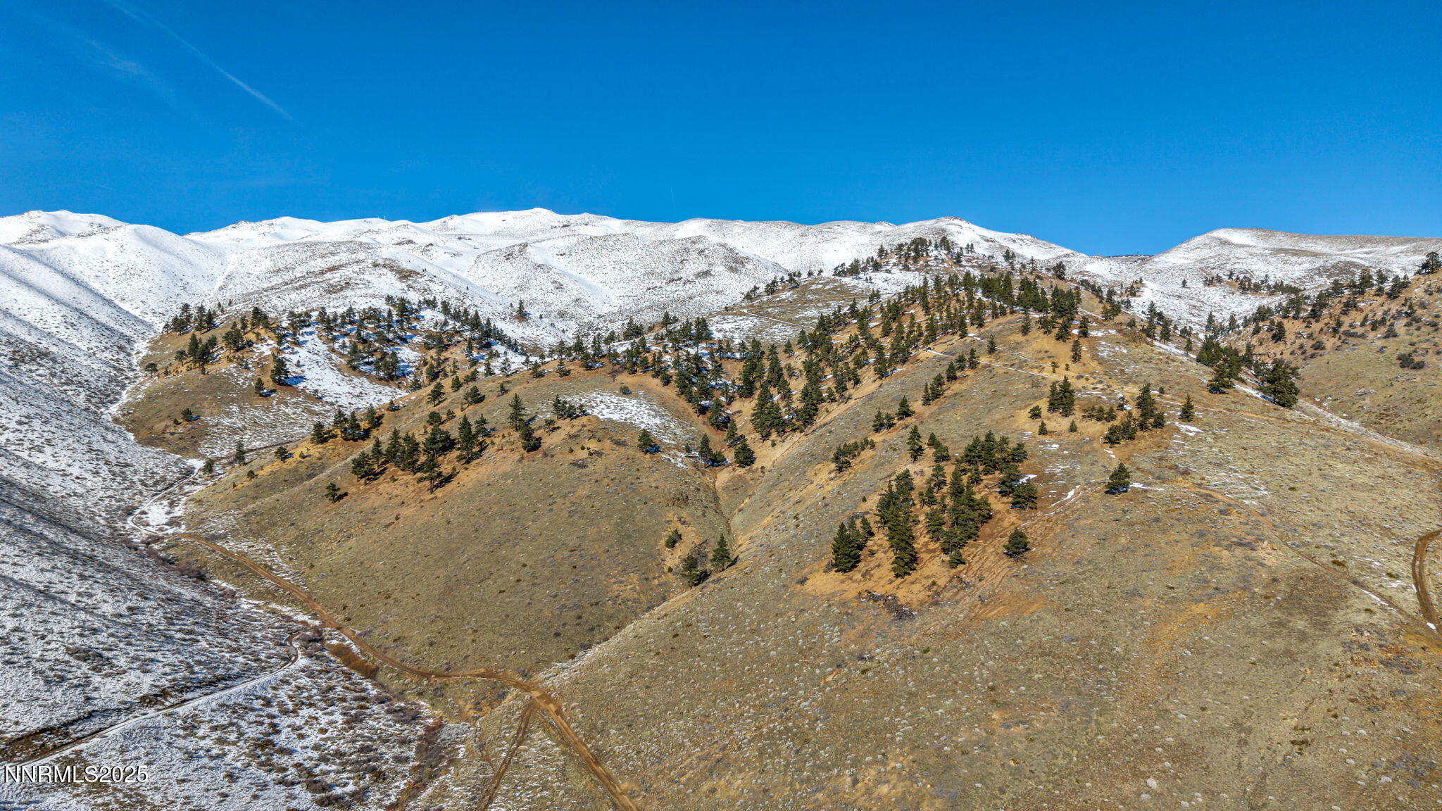 a view of a large mountain with snow in the background