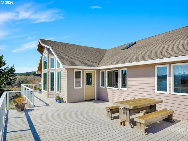 a view of a house with wooden deck and furniture