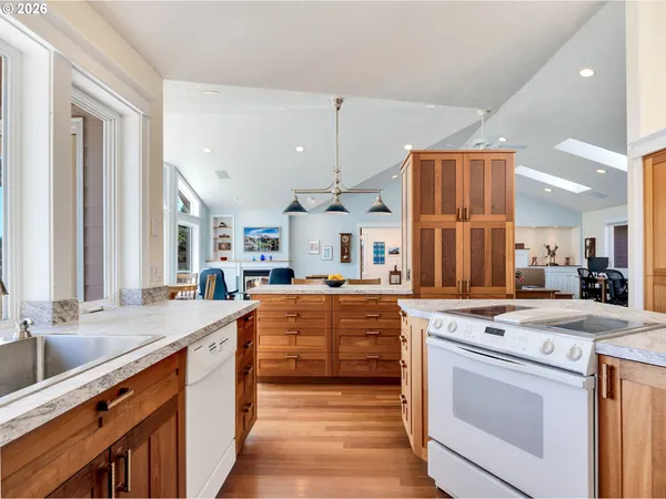 a large kitchen with stainless steel appliances a stove sink and cabinets