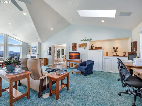 a living room with furniture kitchen view and a wooden floor