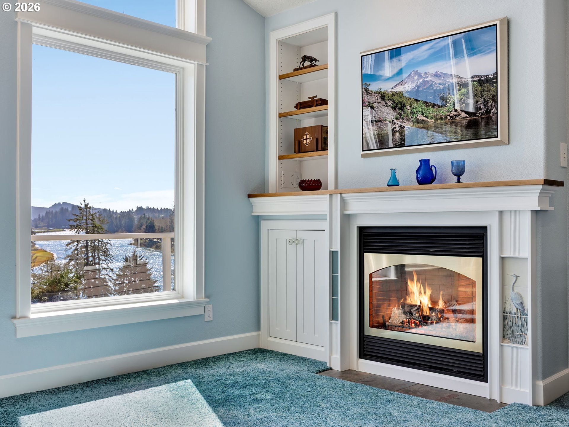 14115 Riverview Meadows Lane Nehalem, OR 97131 - Photo 20 of 39 a living room with a fireplace and a painting on the wall