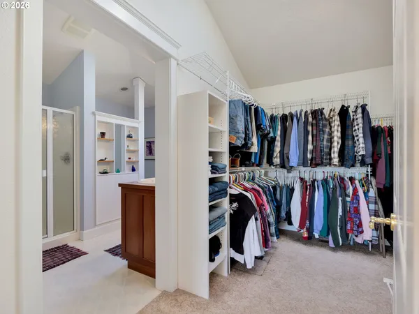 a view of walk in closet with clothes