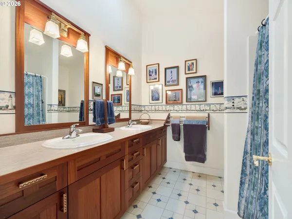 a spacious bathroom with double vanity and a mirror