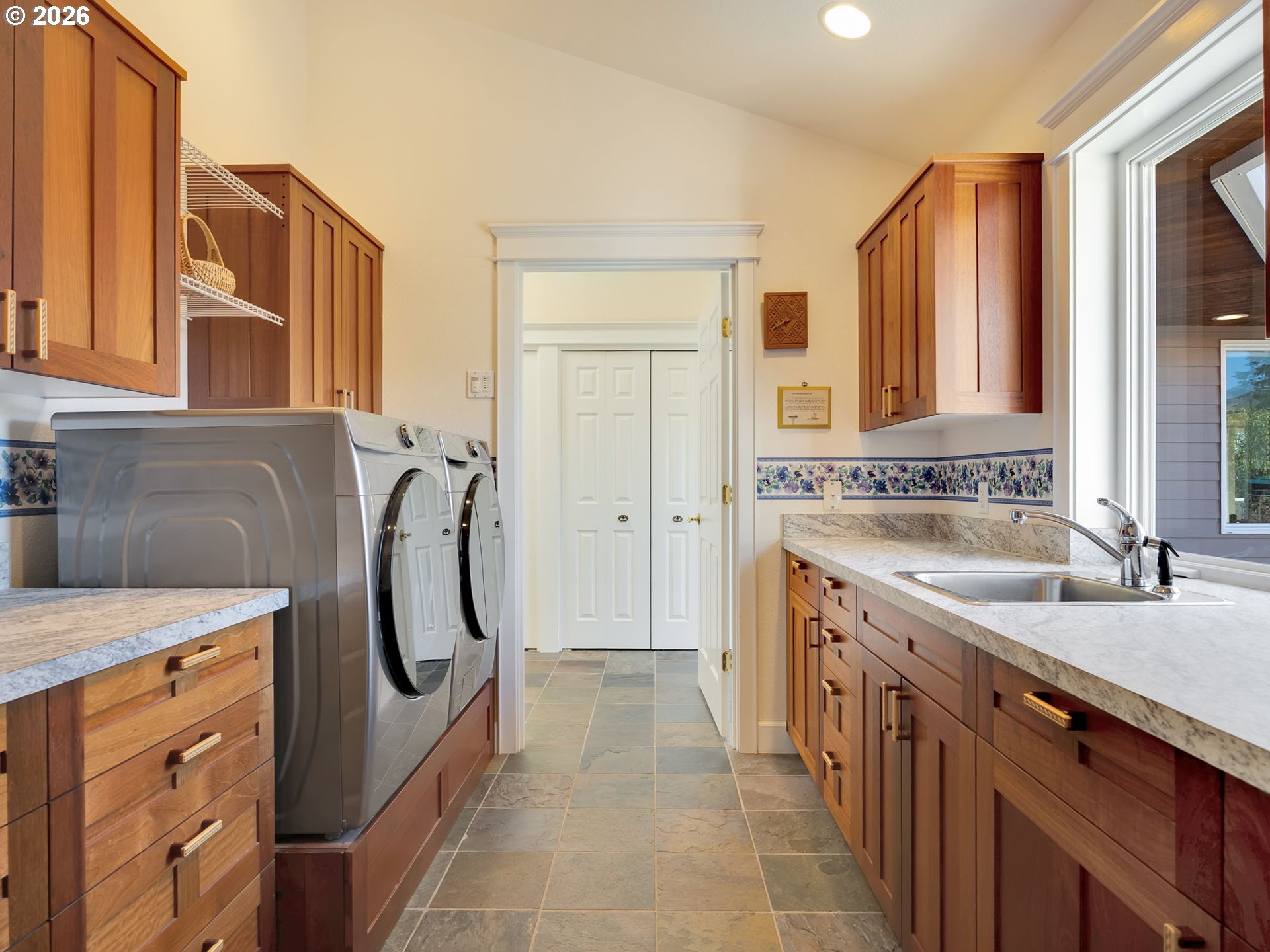 14115 Riverview Meadows Lane Nehalem, OR 97131 - Photo 33 of 39 a utility room with stainless steel appliances granite countertop a sink a washer and dryer with wooden cabinets