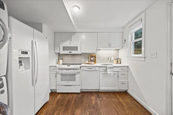 a kitchen with stainless steel appliances a sink cabinets and wooden floor