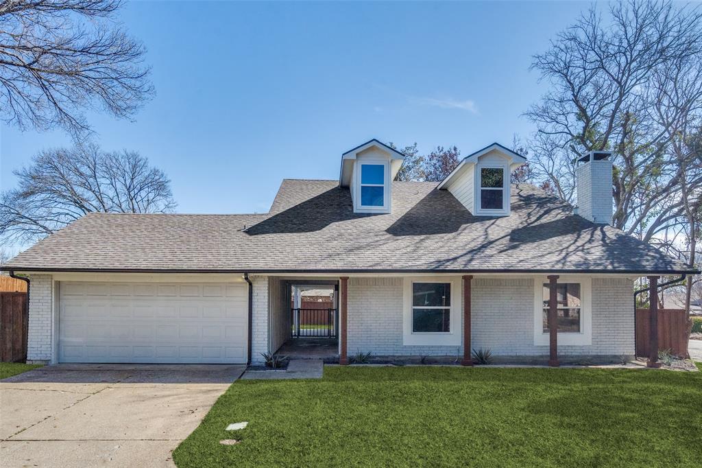 a front view of a house with a garden and yard