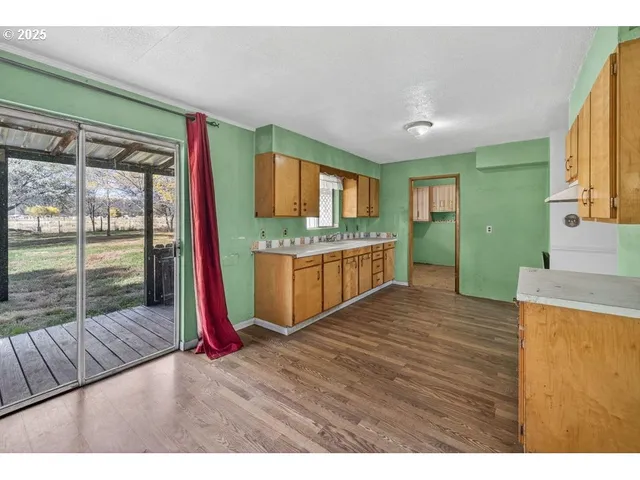 a view of kitchen with kitchen island wooden floor and window
