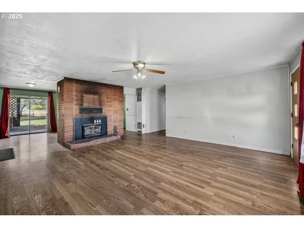 a view of empty room with wooden floor and fireplace