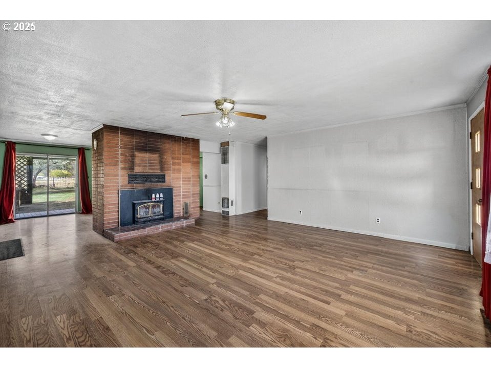 3464 Rimrock Acres Loop Prineville, OR 97754 - Photo 14 of 48 a view of empty room with wooden floor and fireplace