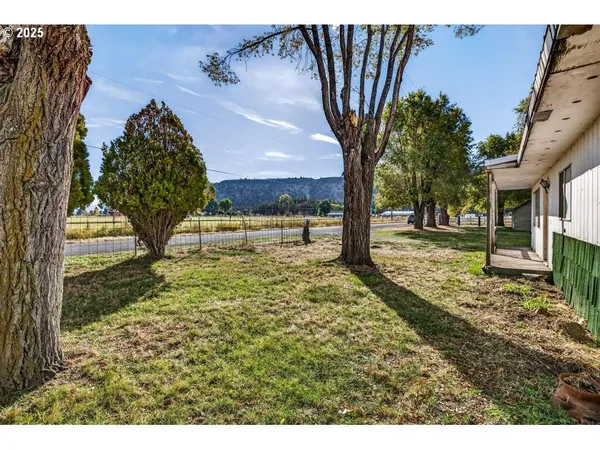 a view of a yard with wooden fence