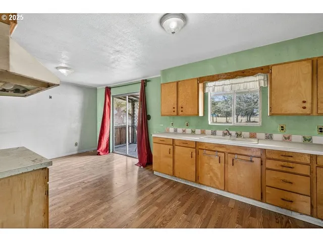 a view of a kitchen with wooden floor and electronic appliances
