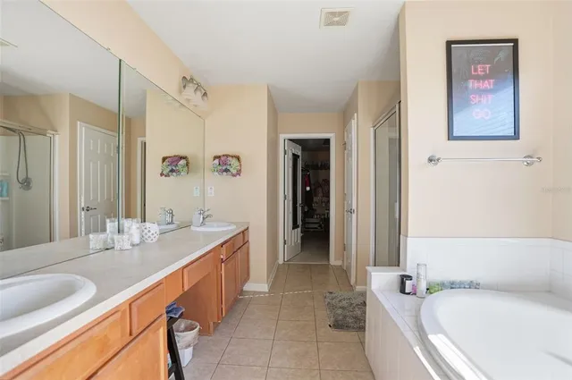 a bathroom with a granite countertop tub sink and mirror