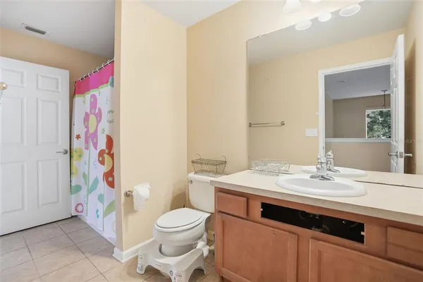 a bathroom with a sink a toilet and shower curtain