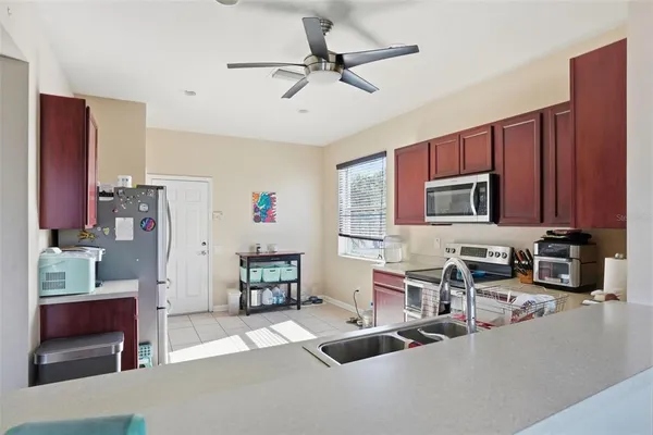 a living room with furniture a flat screen tv and kitchen view