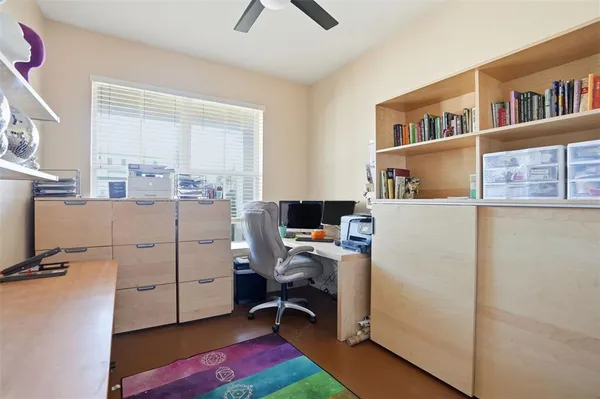 a view of a workspace with furniture and a window
