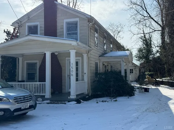 an empty room with wooden floor fireplace and windows