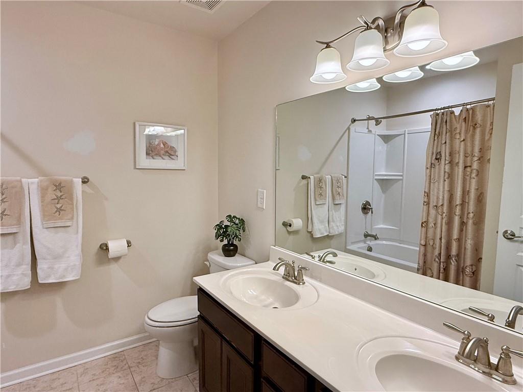 3451 Graham Way Southwest Lilburn, GA 30047 - Photo 31 of 66 a bathroom with a sink vanity granite toilet and a mirror