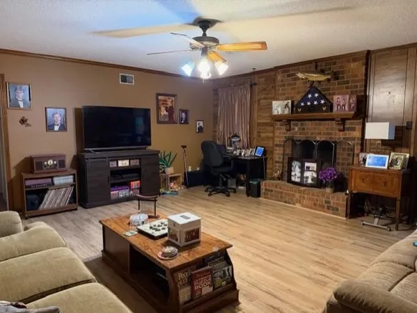 a living room with furniture a fireplace and a flat screen tv